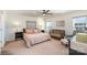 Spacious bedroom with a ceiling fan, crib, bedside tables, and large windows at 112 Abersham Dr, Mooresville, NC 28115