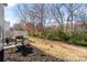 Spacious backyard featuring a patio with a grill and seating, surrounded by trees and a fence at 11708 Huxley Rd, Charlotte, NC 28277