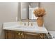 Stylish bathroom featuring a wooden vanity with quartz countertop, gold faucet, and decorative mirror at 11708 Huxley Rd, Charlotte, NC 28277