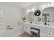 Bright bathroom with dual vanities, modern mirrors, vanity seating, and bathtub at 11708 Huxley Rd, Charlotte, NC 28277