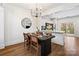 Modern dining area featuring a sleek chandelier and an open view to the kitchen and stainless appliances at 11708 Huxley Rd, Charlotte, NC 28277