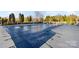 Community pool with a pool cover surrounded by lush landscaping and mature trees at 11708 Huxley Rd, Charlotte, NC 28277