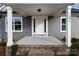 Covered front porch with brick trim, new concrete and a white door with gray siding at 130A Springway Dr, Kannapolis, NC 28081