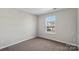 Bedroom featuring a large window providing natural light and neutral carpet at 13923 Singleleaf Ln, Charlotte, NC 28278