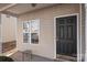 Inviting entryway featuring a classic black front door, neutral siding, and a charming small table at 13923 Singleleaf Ln, Charlotte, NC 28278