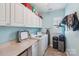 Bright laundry room with appliances, counter space, and storage cabinets at 14621 Brannock Hills Dr, Charlotte, NC 28278