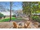 Serene backyard with mature trees, a cozy fire pit area, and a view of the home's exterior at 1474 Callender Nw Ln, Charlotte, NC 28269