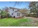 Back exterior showcasing a well-maintained lawn, patio with pergola, and charming home architecture at 1474 Callender Nw Ln, Charlotte, NC 28269