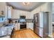 Modern kitchen featuring stainless steel appliances, granite countertops, and white cabinetry at 1474 Callender Nw Ln, Charlotte, NC 28269