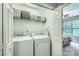 Bright laundry room featuring a washer, dryer, storage shelf, and view into the bedroom at 1474 Callender Nw Ln, Charlotte, NC 28269