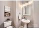 Stylish powder room features a pedestal sink, framed mirror, and neutral paint at 1474 Callender Nw Ln, Charlotte, NC 28269