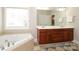 Bathroom featuring double sink vanity, soaking tub, and neutral tile flooring at 1512 Pecan Ave, Charlotte, NC 28205