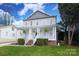 Inviting home featuring a full front porch, mature landscaping, and lush green lawn at 1512 Pecan Ave, Charlotte, NC 28205