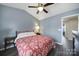 This bedroom features wood-look floors, neutral walls, a ceiling fan and a lamp on the nightstand at 1559 Maypine Commons Way, Rock Hill, SC 29732