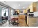 Bright kitchen features a breakfast bar, black appliances, wood cabinets and sliding glass door to the porch at 1559 Maypine Commons Way, Rock Hill, SC 29732