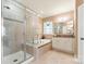 Well-lit bathroom featuring a glass shower, soaking tub, window, and vanity with cabinets at 16023 Rushwick Dr, Huntersville, NC 28078