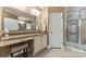 Well-lit bathroom featuring a glass shower, granite vanity with cabinets, and dressing table at 16023 Rushwick Dr, Huntersville, NC 28078