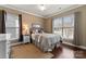 Comfortable bedroom with hardwood floors, ceiling fan, and two windows providing natural light at 16023 Rushwick Dr, Huntersville, NC 28078