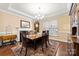 Formal dining room featuring hardwood floors, crown molding, a large table, and bright window at 16023 Rushwick Dr, Huntersville, NC 28078