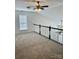 This carpeted loft area has a ceiling fan and a window that provides natural light at 1629 Backcreek Ln, Gastonia, NC 28054