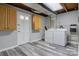 Well-lit laundry room features ample storage with wooden cabinets and white washer and dryer at 1740 Young Dr, Conover, NC 28613