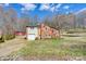 Two-story home with a brick and vinyl exterior, accompanied by a one-car garage and a red barn, with ample lawn space at 1740 Young Dr, Conover, NC 28613