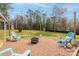 Brick patio featuring outdoor seating around a fire pit, surrounded by a well-maintained lawn and mature landscaping at 198 33Rd Nw St, Hickory, NC 28601