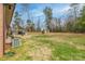 Spacious backyard featuring a well-maintained lawn, patio area with seating, mature trees, and storage sheds at 198 33Rd Nw St, Hickory, NC 28601