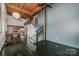 Living room featuring stairs to a loft, wood beam ceiling and kitchen in the background at 201 S Hoskins Rd # 131, Charlotte, NC 28208