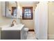 Bathroom with white vanity, modern fixtures, shower with white curtain, and a window for natural light at 201 Wiley Ave, York, SC 29745