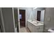 A bathroom with a double vanity, neutral walls, and a view into the bedroom next door at 2108 Cranberry Woods Ct, Charlotte, NC 28208