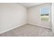 Empty bedroom with plush carpeting and a single window offering natural light at 2130 Old Rivers Rd, Concord, NC 28027