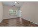 Bright bedroom with a ceiling fan, window, modern wood flooring, and white trim at 2592 Brackley Nw Pl, Concord, NC 28027