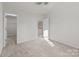 Bedroom with plush neutral carpet, adjoining bath, and ample natural light at 2592 Brackley Nw Pl, Concord, NC 28027