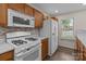 Kitchen with white appliances and modern backsplash at 2592 Brackley Nw Pl, Concord, NC 28027