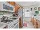 Bright kitchen featuring white appliances, wood cabinets, ample counter space, and natural light at 2592 Brackley Nw Pl, Concord, NC 28027