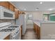 Kitchen with white appliances and modern backsplash near the window and doorway at 2592 Brackley Nw Pl, Concord, NC 28027