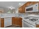 Kitchen featuring white appliances, wood cabinets and luxury backsplash at 2592 Brackley Nw Pl, Concord, NC 28027
