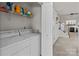 Convenient laundry room with washer, dryer, and shelving for storage solutions at 2592 Brackley Nw Pl, Concord, NC 28027