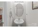 A powder room featuring a pedestal sink, oval mirror, and neutral paint at 2592 Brackley Nw Pl, Concord, NC 28027