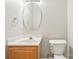 Bright bathroom featuring a round mirror, sleek sink and vanity, and modern toilet for a clean aesthetic at 3010 Uxbridge Woods Ct, Charlotte, NC 28205