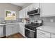 Modern kitchen with stainless steel appliances, white cabinets, quartz countertops, and a stylish backsplash at 302 Flanders Dr, Mooresville, NC 28117