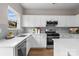 Modern kitchen showcasing white cabinets, stainless steel appliances, granite countertops, and a stylish backsplash at 302 Flanders Dr, Mooresville, NC 28117