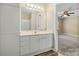 Bright bathroom with large mirror, white vanity and drawers, open doorway to bedroom, and wood-look vinyl flooring at 304 Valley Brook Se Ln, Concord, NC 28025