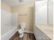 Bright bathroom featuring a tub and shower combination with a modern vanity and vinyl wood-look flooring at 304 Valley Brook Se Ln, Concord, NC 28025