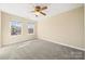 Bright bedroom filled with natural light, two windows, neutral walls and carpet and a ceiling fan at 304 Valley Brook Se Ln, Concord, NC 28025