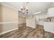 Dining room featuring wood floors, classic chandelier, and a view into the kitchen at 304 Valley Brook Se Ln, Concord, NC 28025