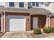 Townhome exterior features a garage, brick facade, and well-maintained landscaping at 304 Valley Brook Se Ln, Concord, NC 28025