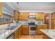 A classic kitchen featuring stainless steel appliances, granite countertops, wood cabinets, and a stainless steel sink at 3101 Colvard Park Way, Charlotte, NC 28269