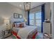 Cozy bedroom featuring a large window with blue drapes, tufted headboard, and decorative lamps at 316 Basil Dr, Indian Trail, NC 28079